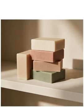 A stack of handmade soap bars in soft natural colours